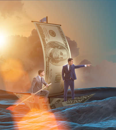 Business partnership with businessmen sailing on dollar boatの写真素材
