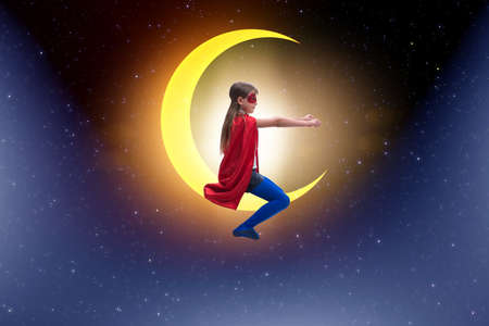 Superhero kid sitting on the moon crescentの写真素材