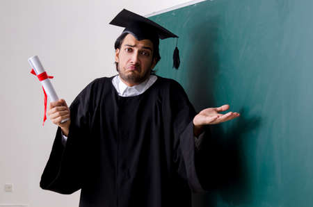 Graduate student in front of green boardの写真素材