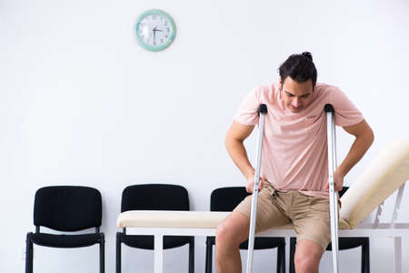 Young injured man waiting for his turn in hospital hallの写真素材
