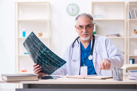 Old male doctor working in the clinicの写真素材