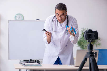 Young male doctor recording video for his blogの写真素材