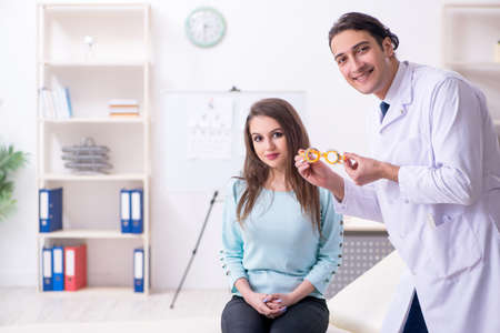 Young woman visiting male doctor oculistの写真素材