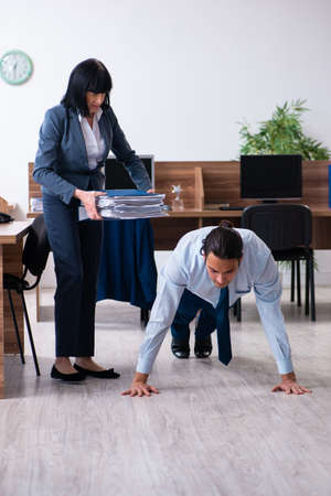 Male employee doing sport exercises in the officeの写真素材