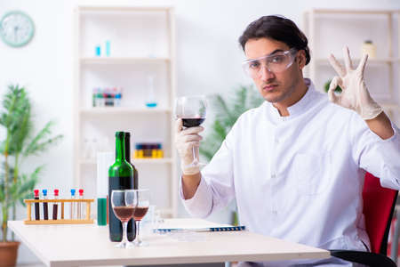 Male chemist examining wine samples at labの写真素材