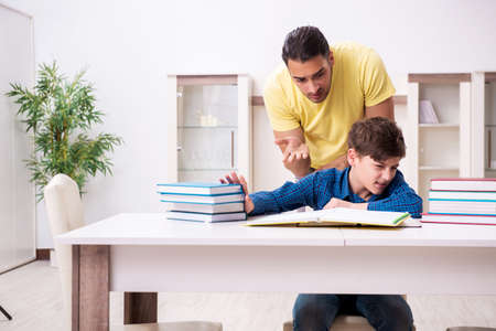 Father helping his son to prepare for schoolの写真素材