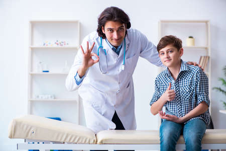 Young doctor examining schoolboy for regular check-upの写真素材