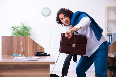 Young male employee unhappy with excessive workの写真素材