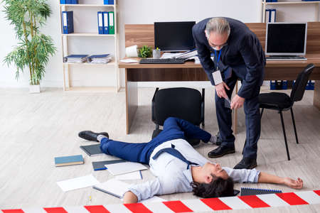 Forensic investigator and dead employee in the officeの写真素材