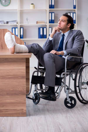 Male employee in wheel-chair in the officeの写真素材
