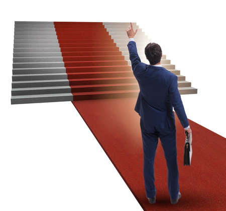 Young businessman climbing stairs and red carpet on white backgrの写真素材