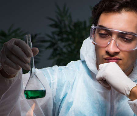 Young male lab chemist late at night in overtime time