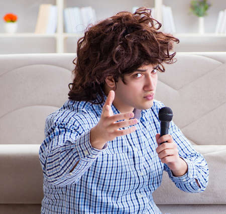 Funny man singing songs in karaoke at homeの写真素材
