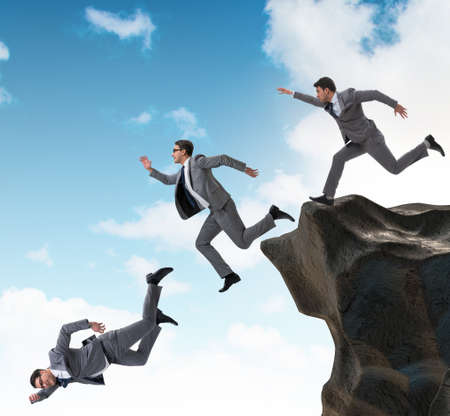 Business people falling off the cliff