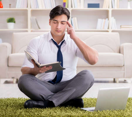 Businessman sitting on the floor in officeの写真素材