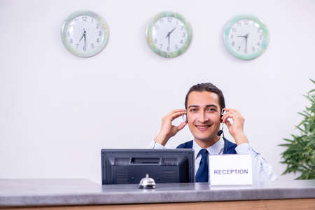 Young man receptionist at the hotel counterの写真素材