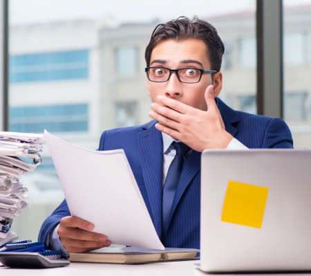 Workaholic businessman overworked with too much work in officeの写真素材