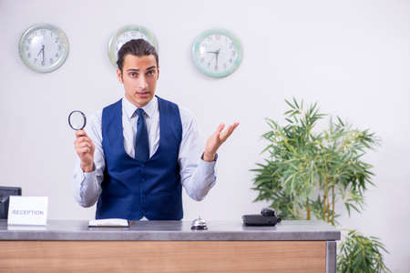 Young man receptionist at the hotel counterの写真素材
