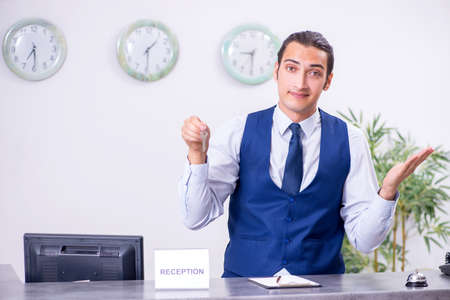 Young man receptionist at the hotel counterの写真素材