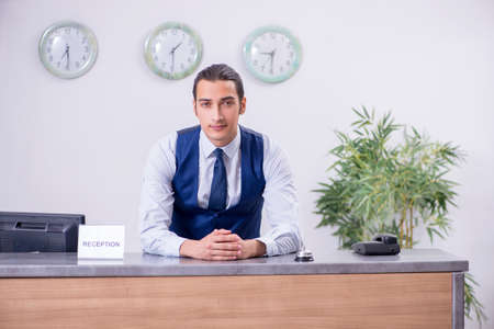 Young man receptionist at the hotel counterの写真素材