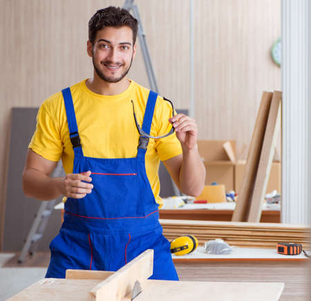 Young repairman carpenter working cutting wood on circular saw