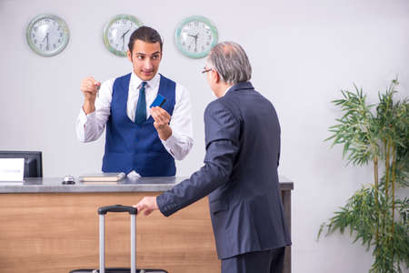 Old businessman at the hotel receptionの写真素材