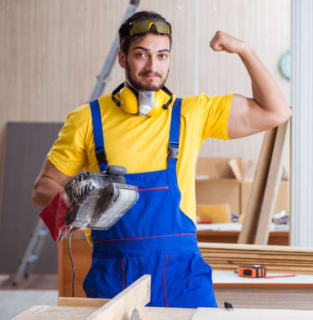 Young repairman carpenter working with power tools electric poliの写真素材