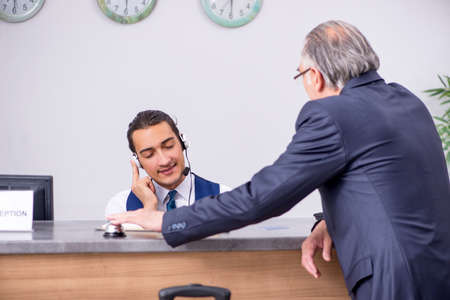 Old businessman at the hotel receptionの写真素材