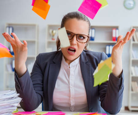 Businesswoman with conflicting priorities in officeの写真素材