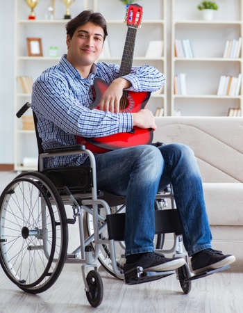 Disabled man playing guitar at homeの写真素材