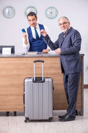 Old businessman at the hotel receptionの写真素材