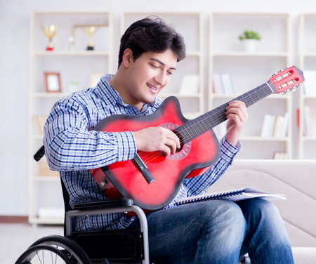 Disabled man playing guitar at homeの写真素材