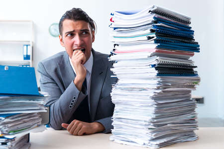 Businessman with heavy paperwork workloadの写真素材