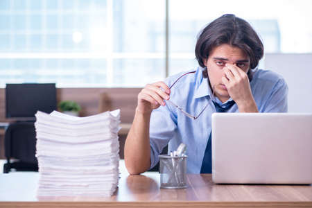 Young employee unhappy with excessive workの写真素材