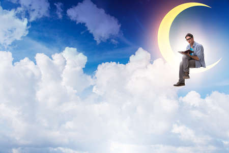 Student reading book on the moon crescentの写真素材