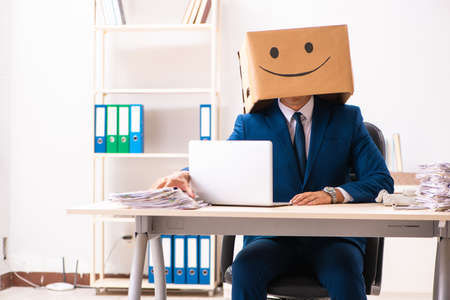 Happy man employee with box instead of his headの写真素材