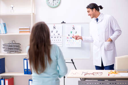Young woman visiting male doctor oculistの写真素材