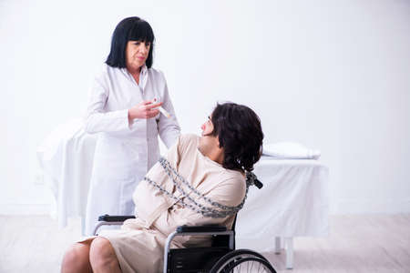 Old female psychiatrist visiting young male patientの写真素材