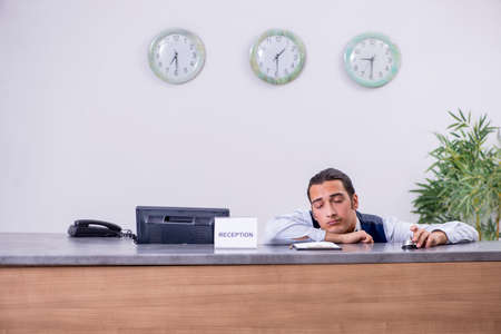 Young man receptionist at the receptionist counter