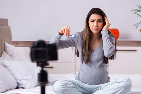 Pregnant woman recording video for her blogの写真素材