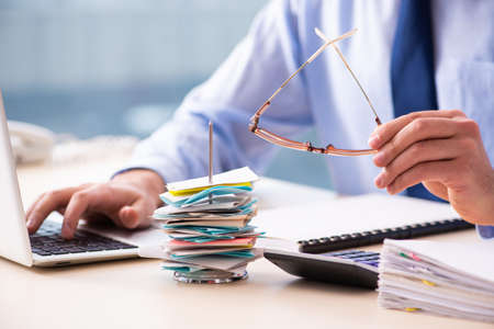 Young male employee in budget planning conceptの写真素材