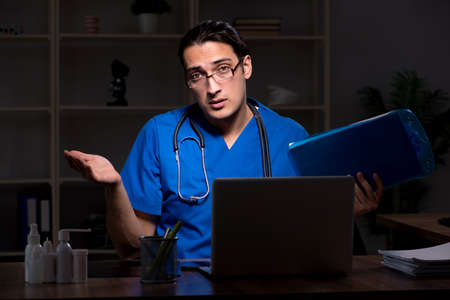 Young male doctor in the hospital at nightの写真素材