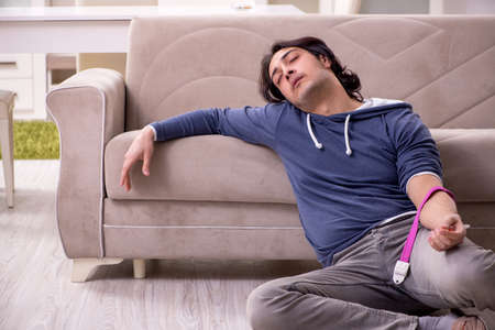 Young man having problems with narcotics at home