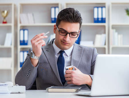 Businessman smoking in office at workの写真素材