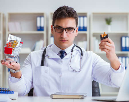 Male doctor in anti-smoking conceptwithcigarette packの写真素材