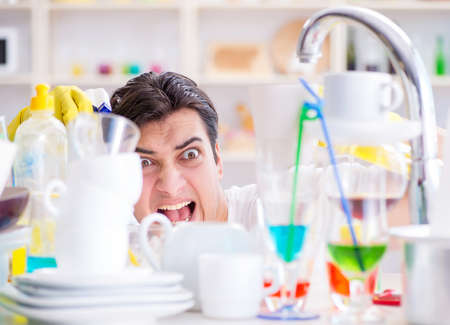 Man frustrated at having to wash dishesの写真素材