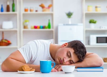 Man falling asleep during his breakfast after overtime workの写真素材