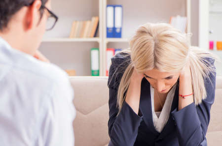Young woman visiting psychiatrist man doctor for consultationの写真素材