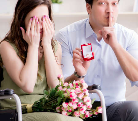 Man making marriage proposal to disabled woman on wheelchairの写真素材