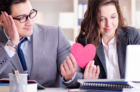 Happy couple working in the same officeの写真素材